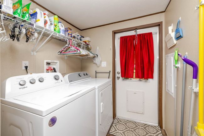 Washroom with crown molding, washing machine and clothes dryer, and laundry area | Image 24