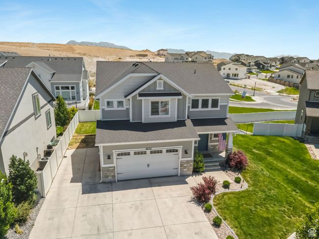 View of front of property with a garage, a residential view, stone siding, driveway, and a porch | Image 4
