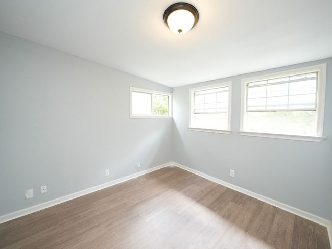 Spare room featuring wood finished floors and lofted ceiling | Image 18