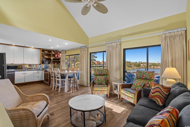 Living room featuring plenty of natural light, a water view, dark wood finished floors, and a ceiling fan | Image 11