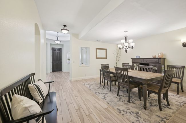 Dining area featuring light wood-style floors, an inviting chandelier, baseboards, and arched walkways | Image 10