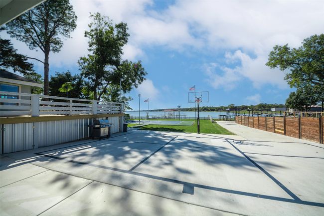 Extra gated parking with basketball hoop, a water view, and grilling area | Image 28