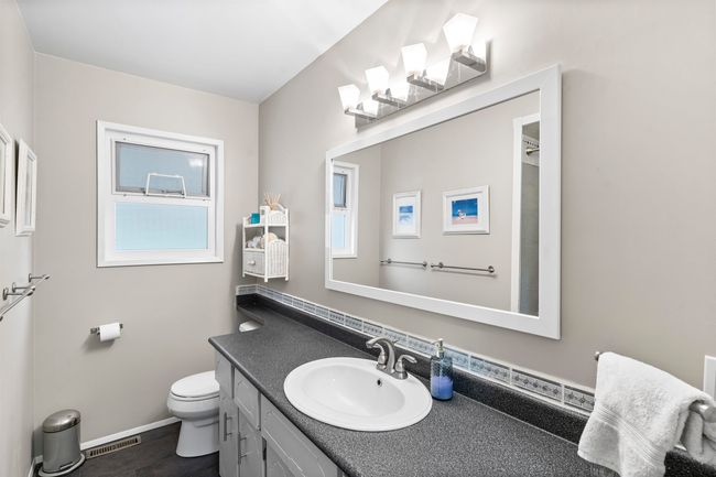Bathroom with toilet, vanity, baseboards, and visible vents | Image 16