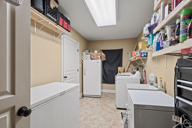 Washroom featuring light floors, washer and clothes dryer, and laundry area | Image 18