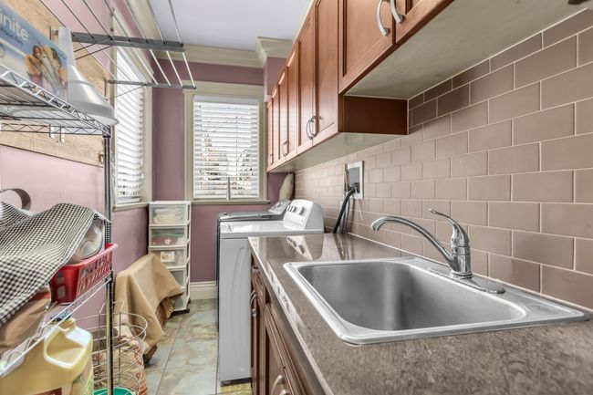 Washroom with cabinet space, washer and clothes dryer, baseboards, and crown molding | Image 18