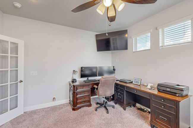 Carpeted office space featuring baseboards and a ceiling fan | Image 29