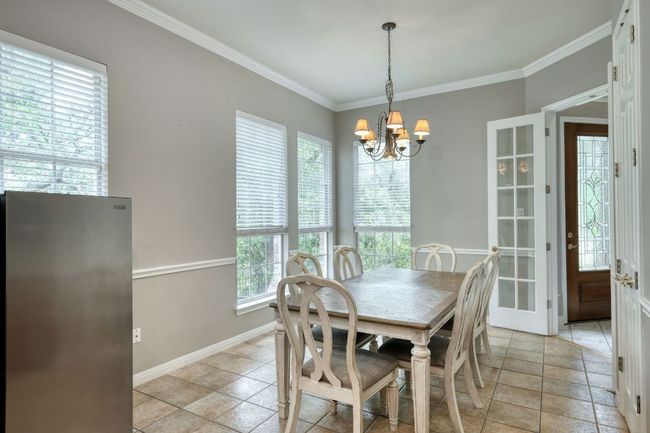 Dining area featuring baseboards, an inviting chandelier, and crown molding | Image 13