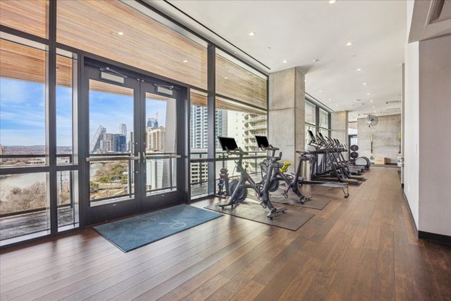Gym featuring recessed lighting, a city view, hardwood / wood-style floors, floor to ceiling windows, and french doors | Image 26
