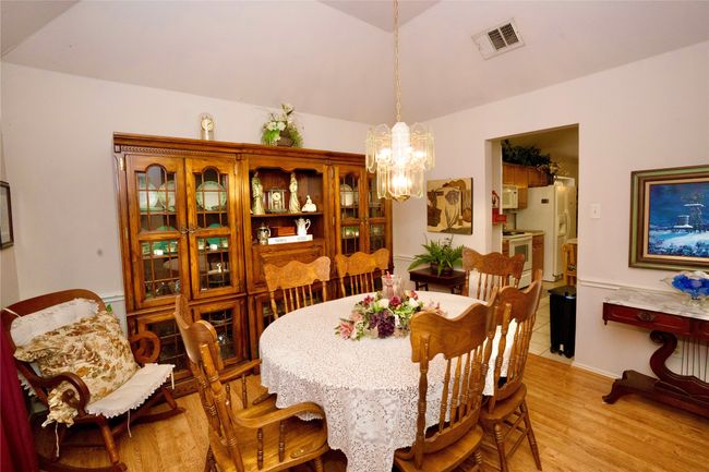 Dining room featuring a chandelier, vaulted ceiling, and light wood-style floors | Image 6