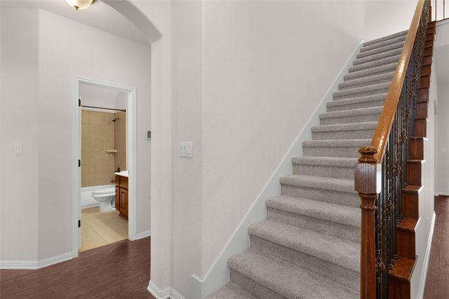 Stairs with arched walkways, baseboards, and wood finished floors | Image 7