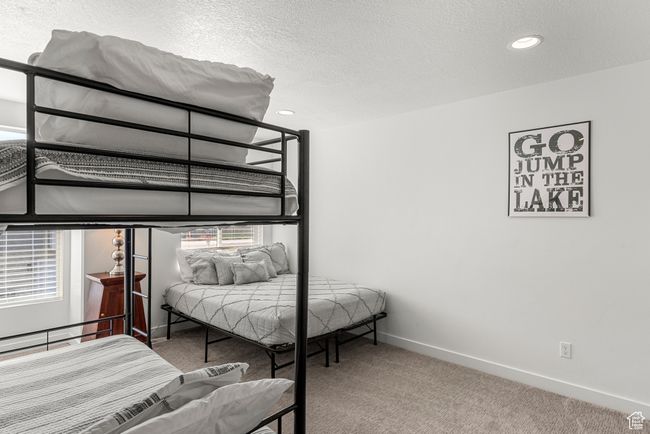 Bedroom with multiple windows, a textured ceiling, baseboards, and carpet floors | Image 26