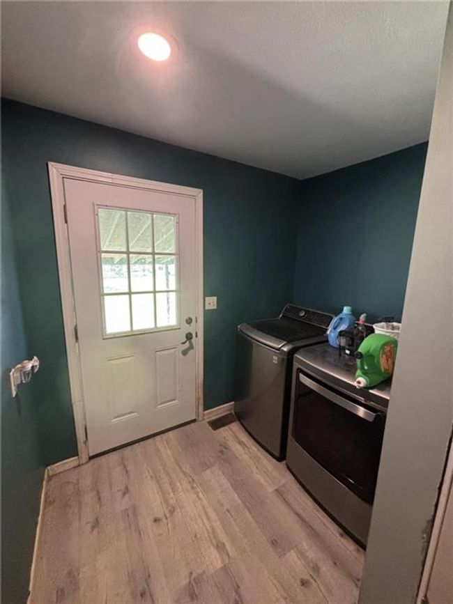 Laundry room featuring washing machine and dryer and light wood-style floors | Image 30