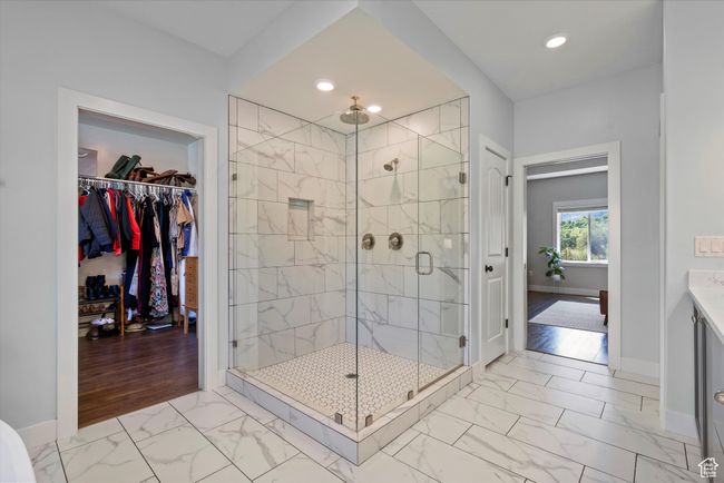 Primary full bathroom featuring marble finish floors, a shower stall, baseboards, a huge walk-in closet, and recessed lighting | Image 35