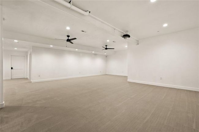 Huge downstairs basement is carpeted with ceiling fans. So much space for entertaining. | Image 44