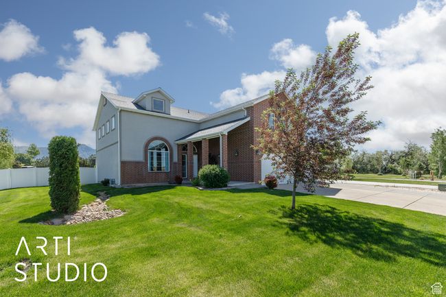 Traditional-style house featuring brick siding, a garage, and stucco siding | Image 4