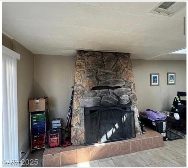 Tiled living room with a tiled fireplace and visible vents | Image 5