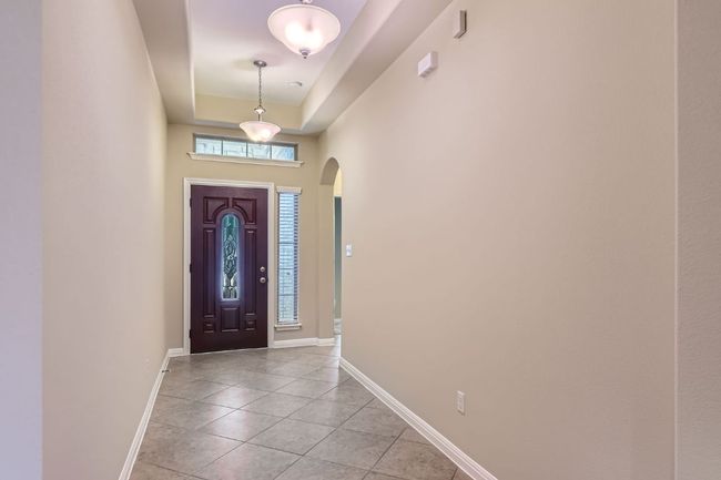 Entryway with light tile patterned flooring and arched walkways | Image 5