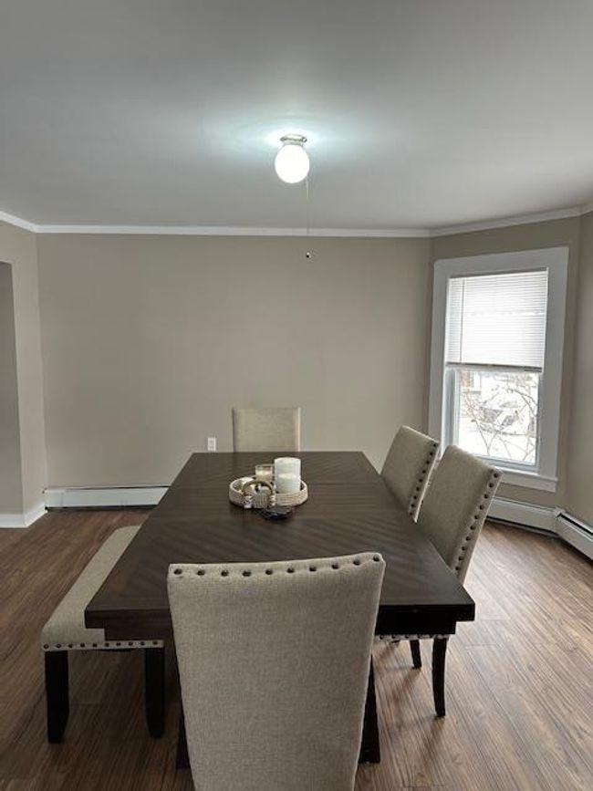 Dining space with baseboard heating, dark hardwood / wood-style floors, and ornamental molding | Image 16