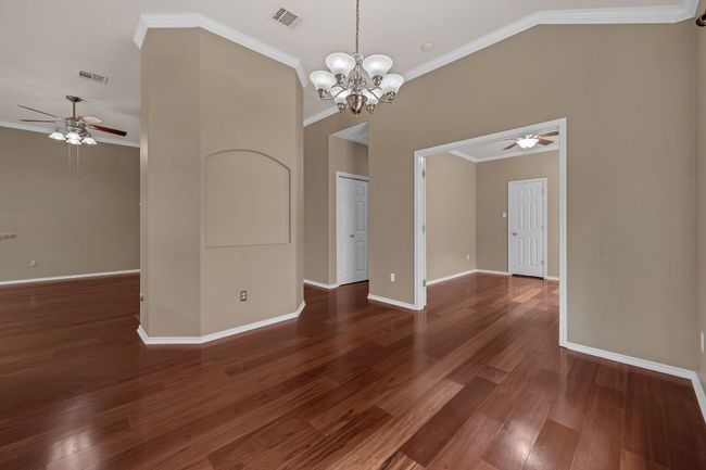 Step inside to discover Brazilian hardwood floors, soaring ceilings with crown molding, and a cozy tile-hearth fireplace anchoring the spacious living area. | Image 4