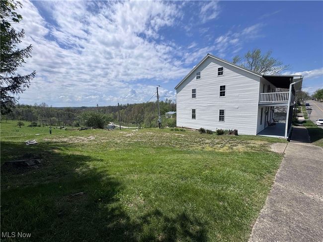 View of side of home with a patio area, a yard, and a balcony | Image 22