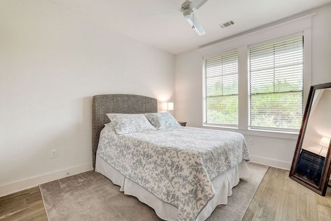 Bedroom with light wood-style floors, baseboards, and a ceiling fan | Image 21