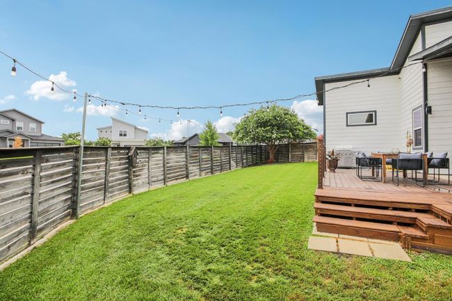 Fenced backyard with a wooden deck | Image 38