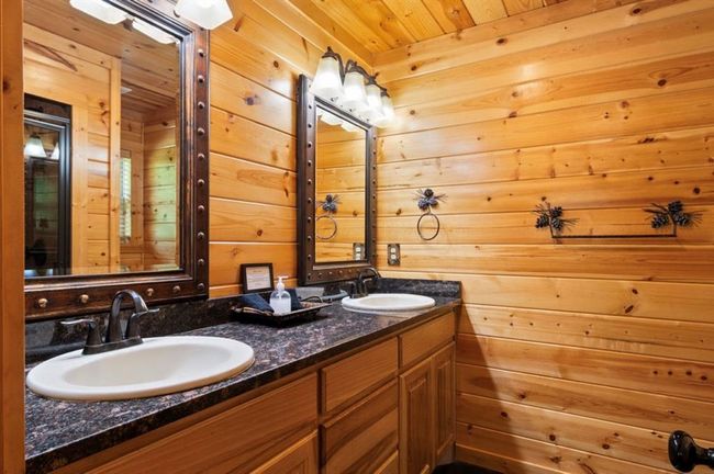 Bathroom with double vanity, wood walls, and wooden ceiling | Image 16