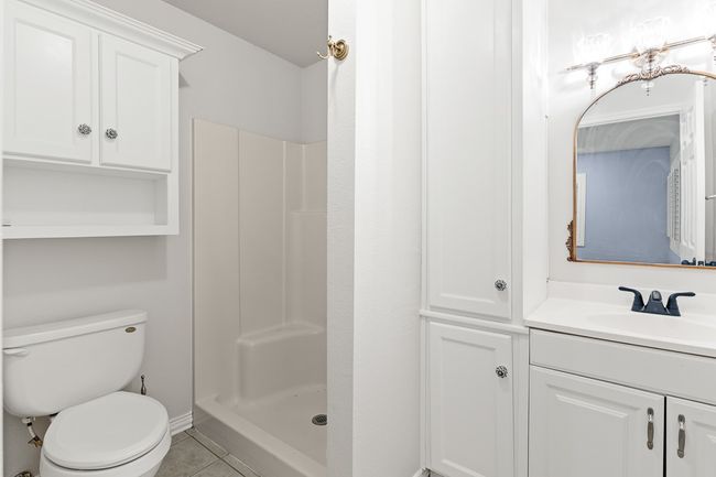 Full bathroom featuring toilet, a stall shower, vanity, and tile patterned flooring | Image 26