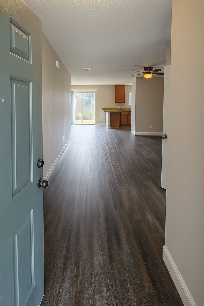 Unfurnished living room featuring dark wood finished floors and a ceiling fan | Image 6