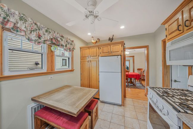 Kitchen with a ceiling fan, light tile patterned flooring, recessed lighting, and white appliances | Image 12