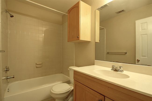Full bathroom with vanity, tiled shower / bath combo, and toilet | Image 20