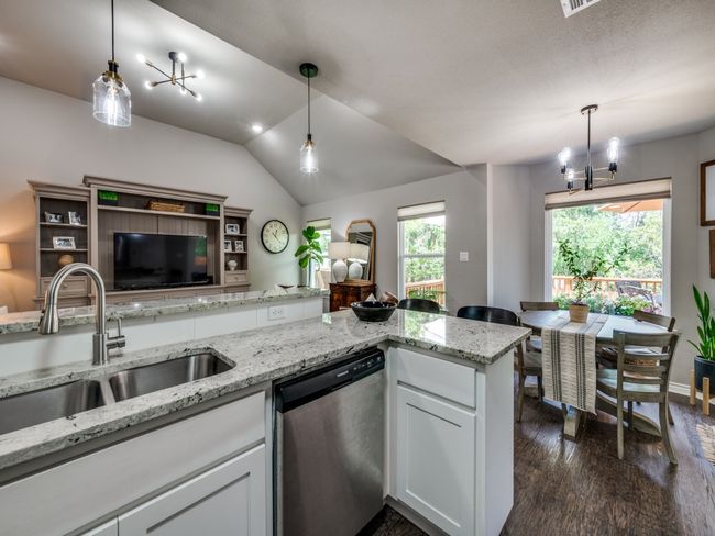 Kitchen featuring dishwasher, a sink, open floor plan, vaulted ceiling, and dark wood-type flooring | Image 11