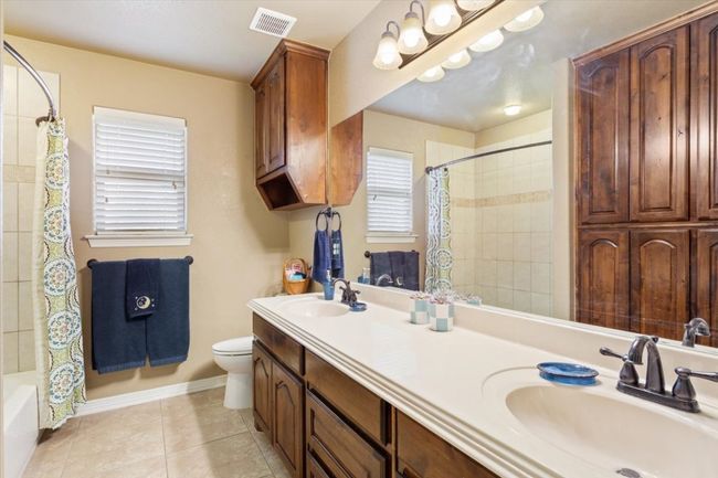 Full bathroom with tile patterned flooring, toilet, visible vents, and a sink | Image 27