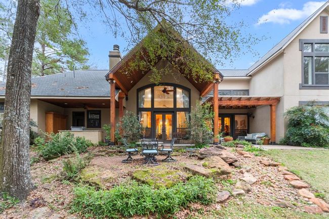 Lush natural landscape and gardens surround this idyllic home. The English flower garden is nestled beside a garden of lilies contained within an iron fence. Nearby in the backyard is a dense stand of wild violets which are striking in bloom and a vegetable garden can be found on the north side of the property. All growing among the beautiful native landscape just steps from the home. | Image 34