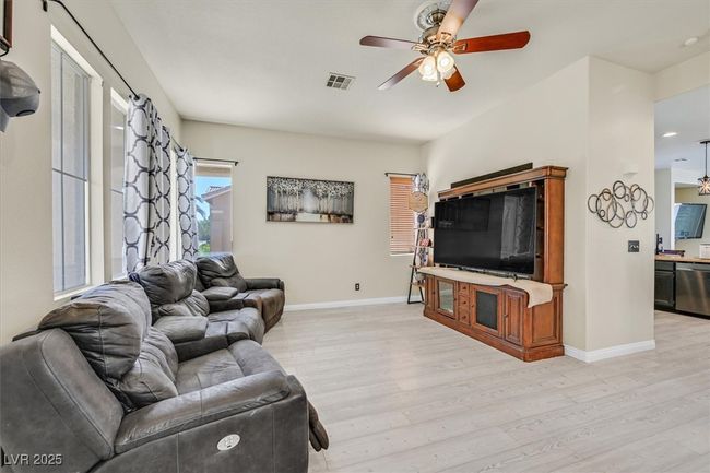 Living area featuring light wood-style flooring, baseboards, visible vents, and ceiling fan | Image 8
