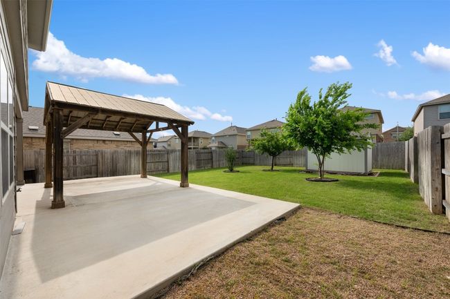 View of yard with a patio area, a residential view, an outbuilding, and a shed | Image 12