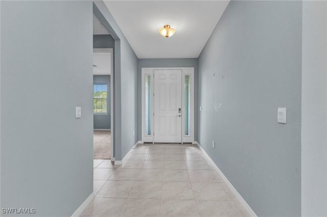 Foyer with light ceramic tile patterned floors and baseboards | Image 9