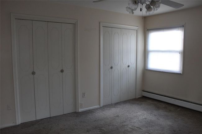 Bedroom featuring ceiling fan, carpeted floor and two double closets | Image 8
