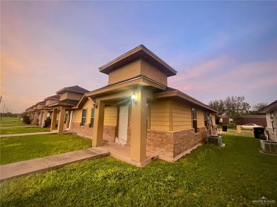 Property exterior at dusk featuring central AC and a yard | Image 1