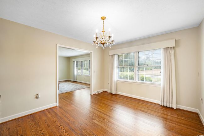 Empty room featuring a chandelier, wood finished floors, and baseboards | Image 28