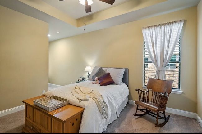 Bedroom featuring carpet flooring, a ceiling fan, a tray ceiling, and baseboards | Image 26