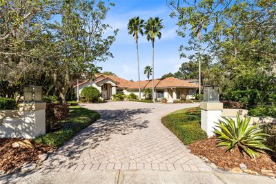 The home is tucked away on an impressive private brick paver driveway located on a quiet culdsac in a small neighborhood of custom built homes. | Image 2