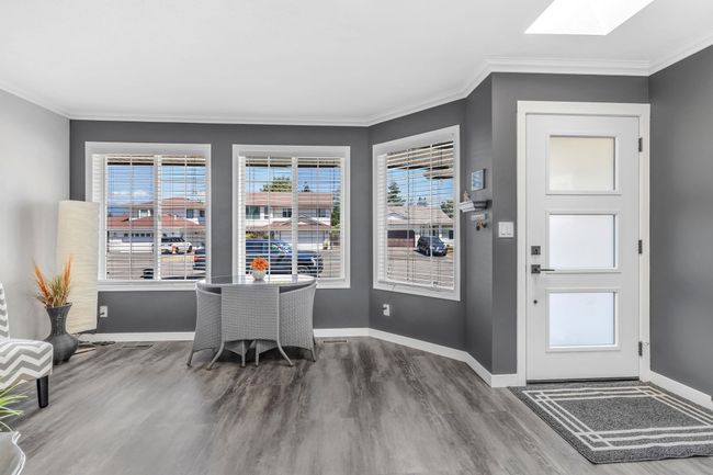Entrance foyer featuring ornamental molding, a skylight, wood finished floors, and baseboards | Image 5