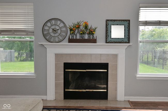 detailed view of a tiled fireplace and baseboards | Image 13