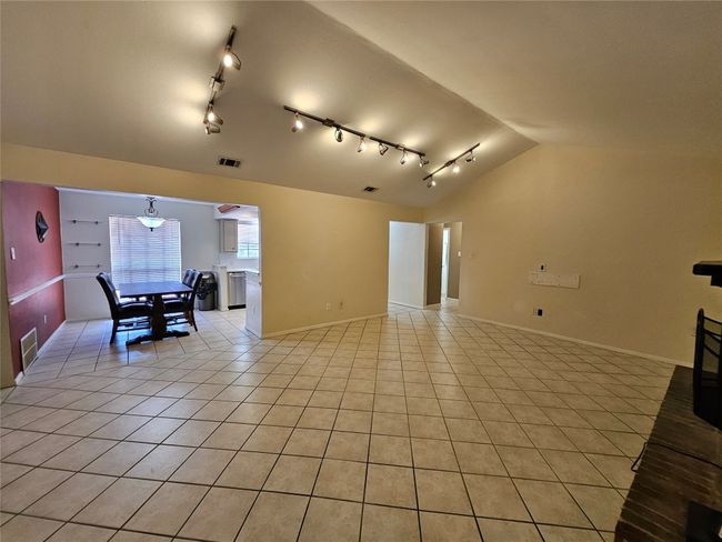 Spare room featuring vaulted ceiling, light tile patterned floors, and rail lighting | Image 5