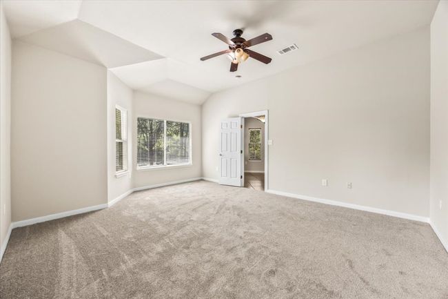 Unfurnished bedroom featuring ceiling fan, carpet, vaulted ceiling, visible vents, and baseboards | Image 16