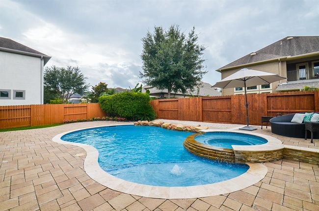 Pool with spa, surrounded with travertine stone. | Image 40