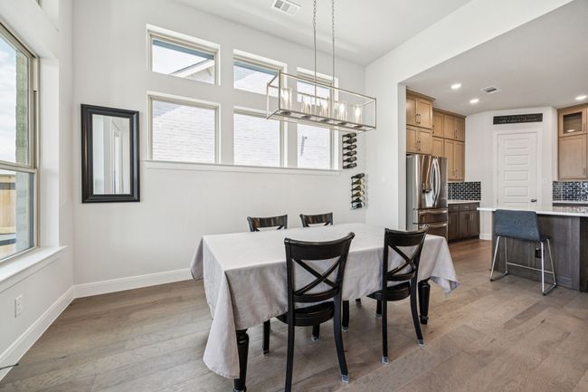 Dining space with light wood finished floors, a chandelier, recessed lighting, and baseboards | Image 25
