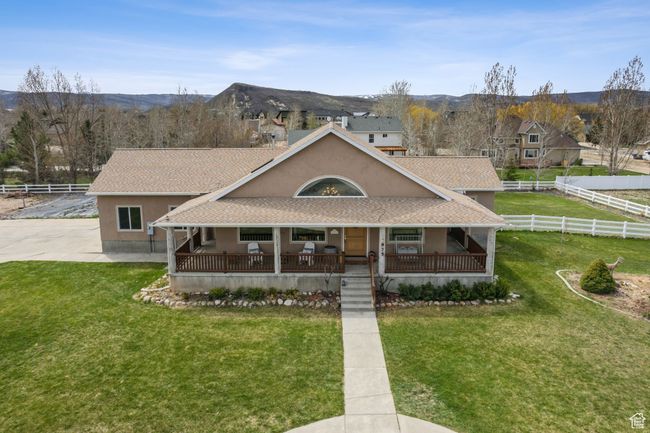 Country-style home with a porch, a front yard, stucco siding, and a shingled roof | Image 59