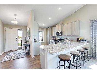 A stunning kitchen layout, all while remaining remarkably functional: The counters are endless, the sink is under-mounted, the range is gas and the microwave is vented to the exterior of the home. Photo of model home, colors will vary. | Image 2